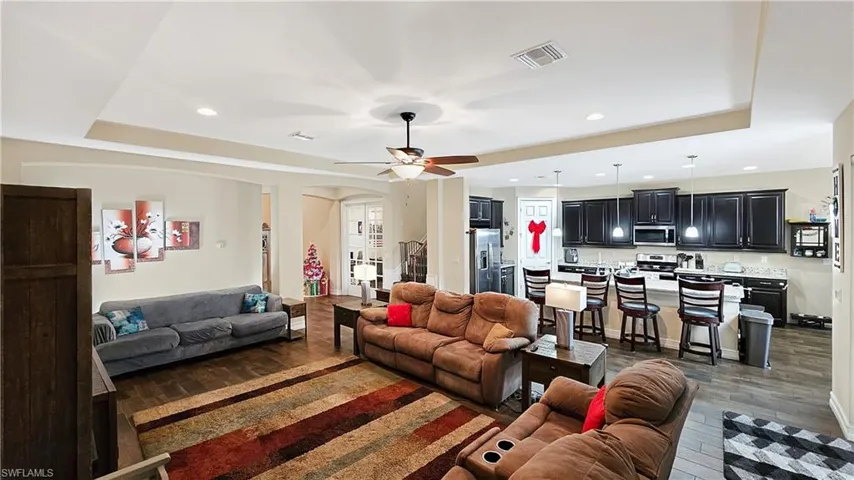Living room with dark hardwood / wood-style flooring and a raised ceiling