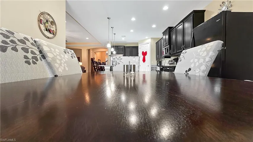 Kitchen with stainless steel appliances, hanging light fixtures, and dark hardwood / wood-style floors