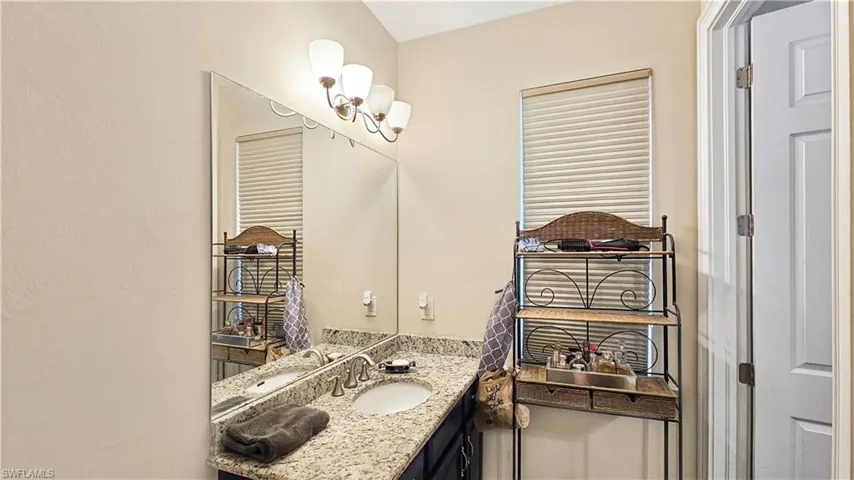 Bathroom featuring tile patterned floors, vanity, and plus walk in shower