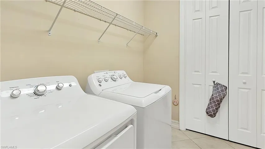 Bathroom with tile patterned flooring, vanity, a shower with shower door, and toilet