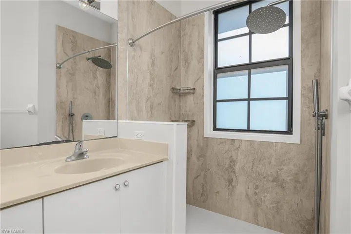 Full bathroom with a marble finish shower and vanity