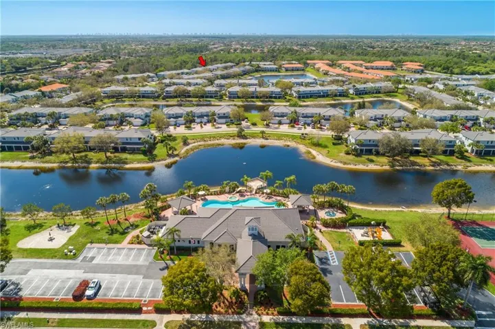 Aerial perspective of suburban area featuring a pool area and a nearby body of water