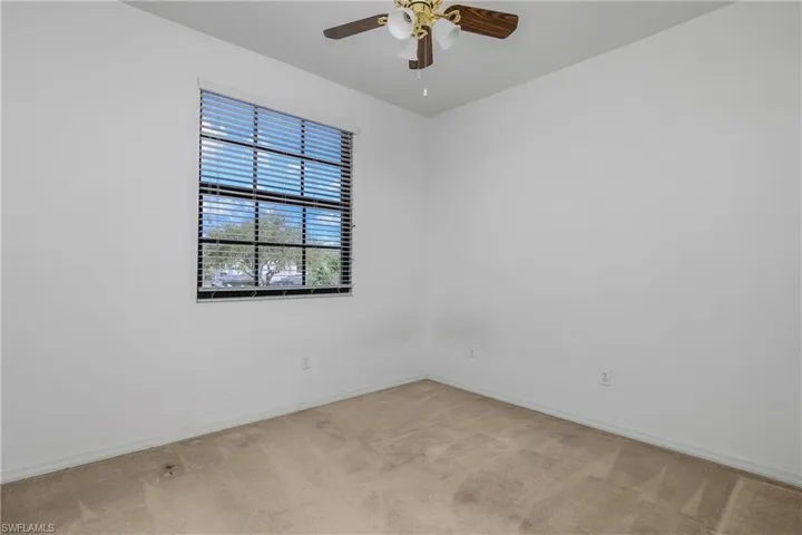 Unfurnished room featuring light colored carpet and ceiling fan