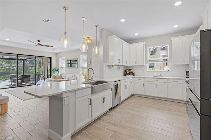 Kitchen featuring a wealth of natural light, sink, decorative backsplash, and a tray ceiling