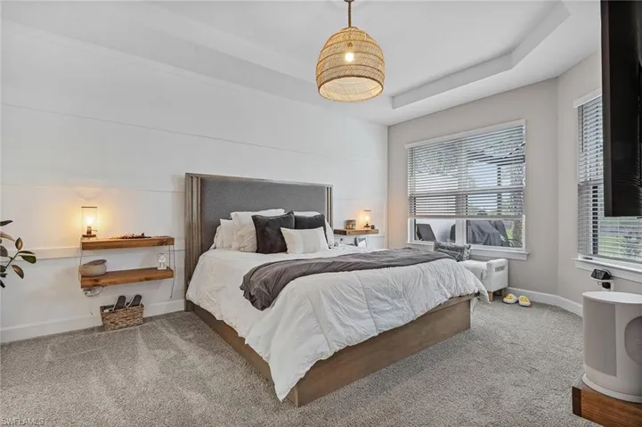 Bedroom featuring a tray ceiling and carpet flooring