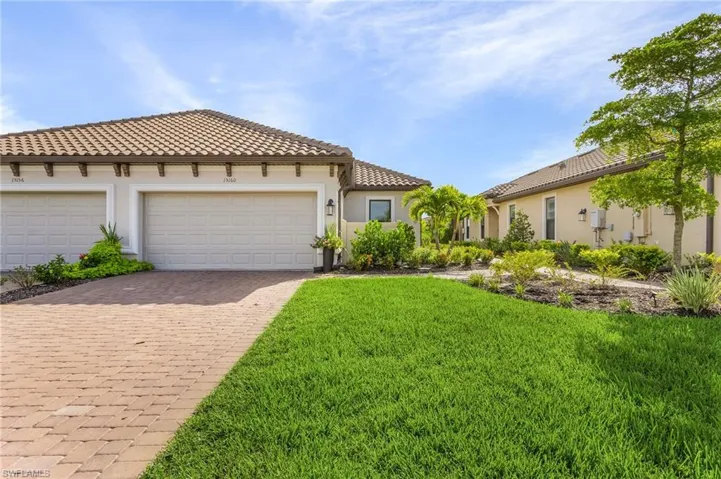 Mediterranean / spanish-style house with a garage and a front lawn