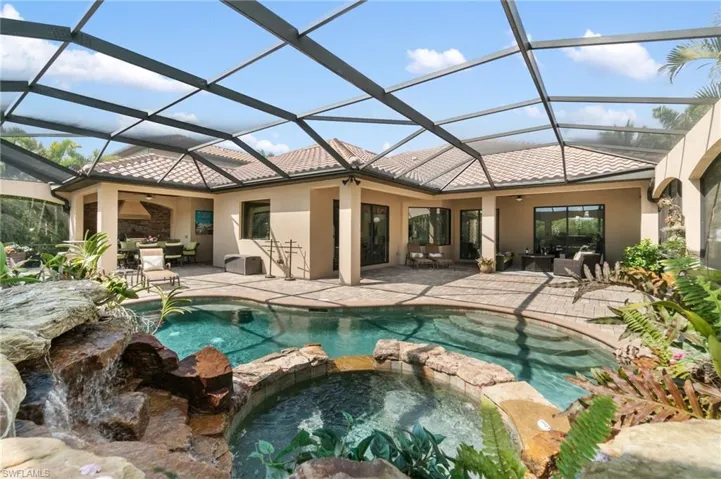 View of pool featuring a ceiling fan, a pool with connected hot tub, a patio, and outdoor dining space