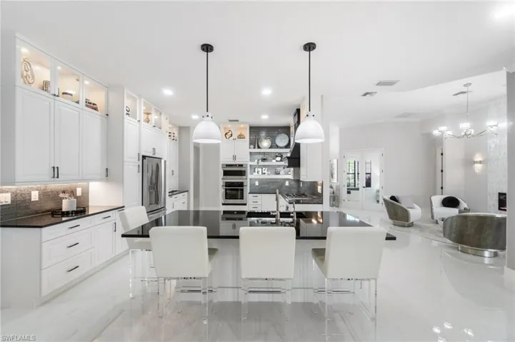 Kitchen featuring appliances with stainless steel finishes, decorative backsplash, dark countertops, a kitchen bar, and recessed lighting