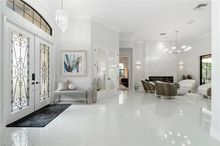 Entrance foyer featuring french doors, a chandelier, and ornamental molding