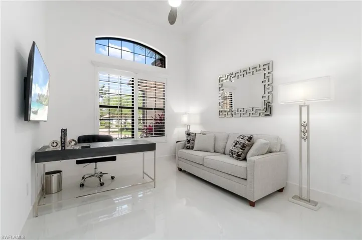 Tiled office space featuring crown molding and ceiling fan
