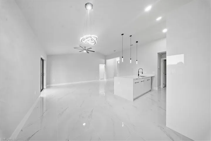 Unfurnished living room with a ceiling fan, light marble finish floors, and recessed lighting