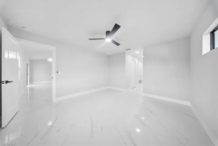 Empty room with ceiling fan, light marble finish floors, and recessed lighting