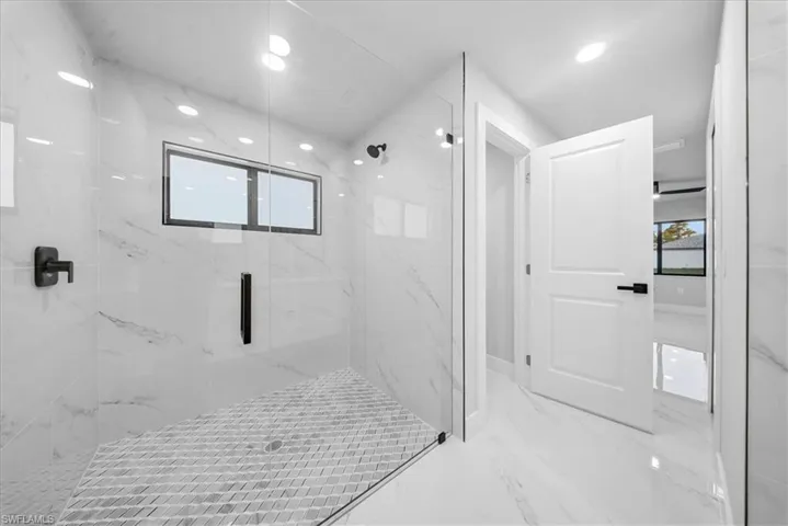 Bathroom with marble tiled flooring, a marble finish shower, and recessed lighting