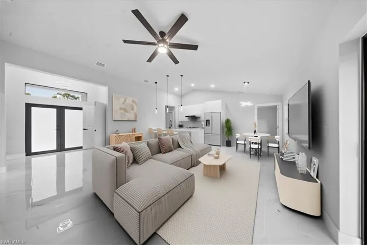 Living room featuring vaulted ceiling, marble finish floors, and ceiling fan