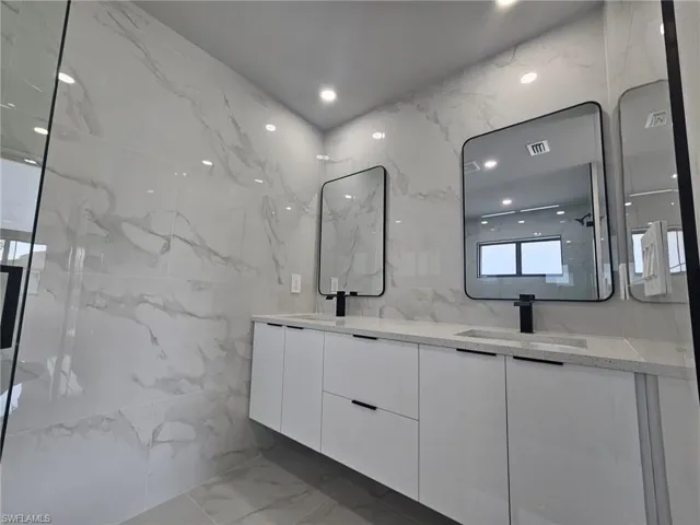 Bathroom with vanity and tile walls