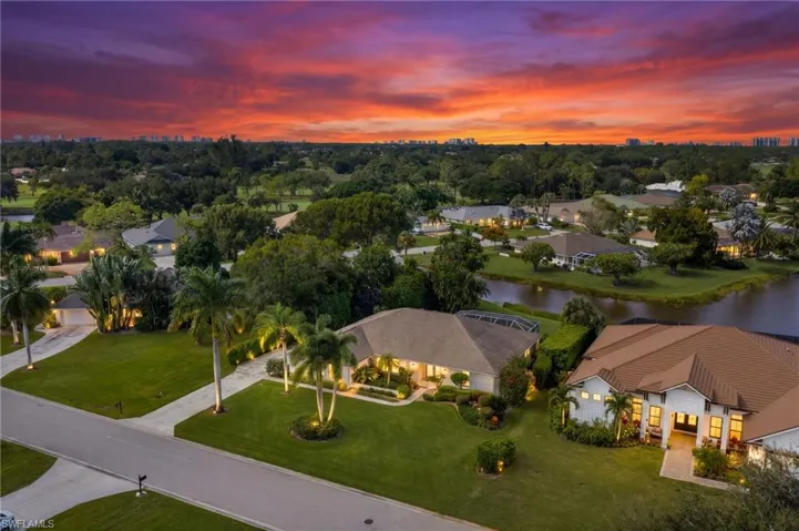 Tropical landscaping and lakeside setting beneath a colorful sunset sky.