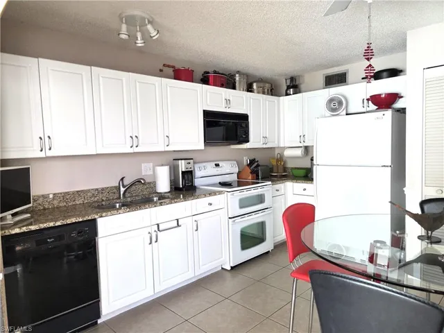 Updated kitchen features raised-panel cabinets and granite counters.
