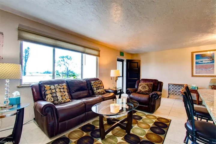 Living room featuring a textured ceiling and light tile patterned floors