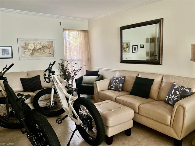 Living area featuring ornamental molding and tile patterned flooring