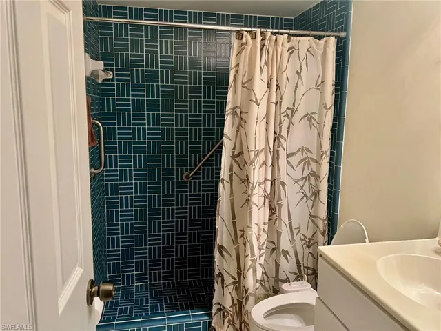 Full bath featuring vanity and tiled shower