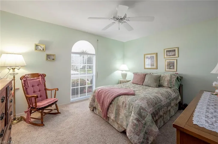 Guest Bedroom featuring light colored carpet, ceiling fan  and large walk in closet