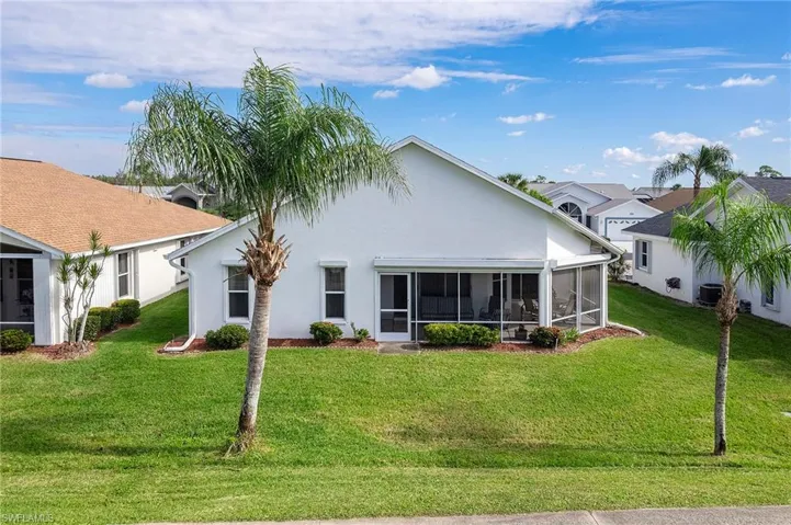 Back of property featuring a sunroom, a yard