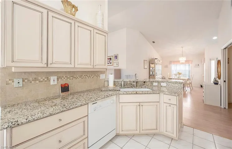 Kitchen featuring kitchen peninsula, sink, cream cabinets, dishwasher, and light hardwood / wood-style floors