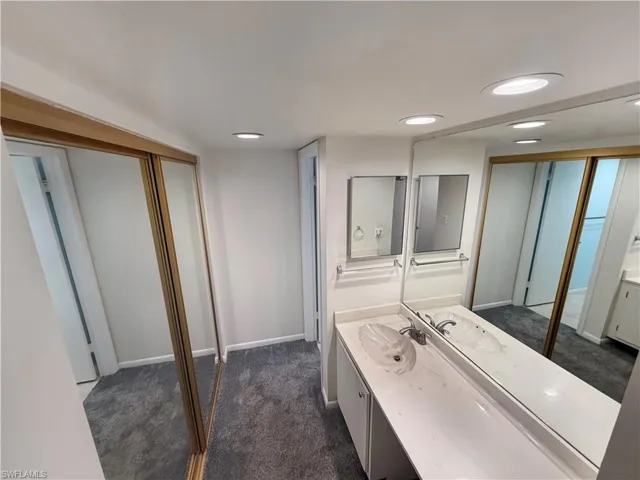 Full bath featuring dark carpet, vanity, and recessed lighting
