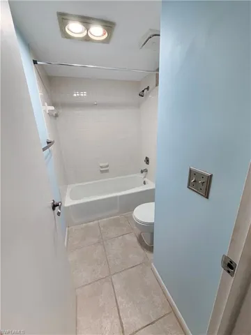 Bathroom featuring light tile patterned floors and bathing tub / shower combination
