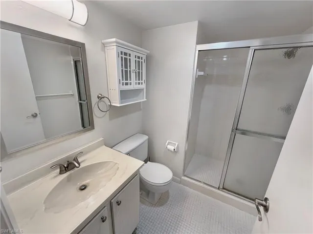 Full bath featuring vanity, a stall shower, and light tile patterned floors
