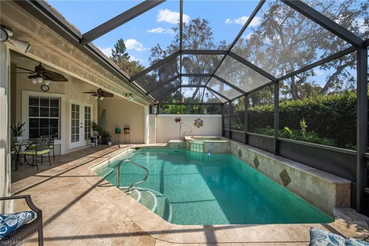 View of pool featuring french doors, ceiling fan, glass enclosure, and a patio area