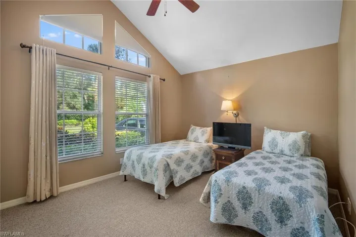 Bedroom featuring ceiling fan, high vaulted ceiling, and carpet