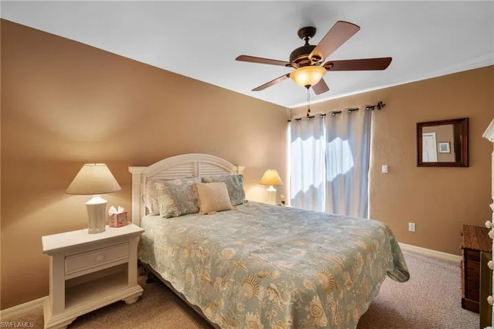 Carpeted bedroom featuring ceiling fan