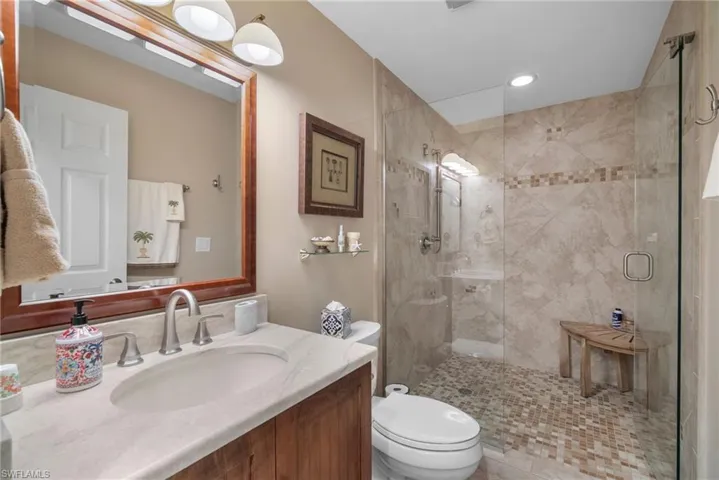 Bathroom with vanity, toilet, and an enclosed shower
