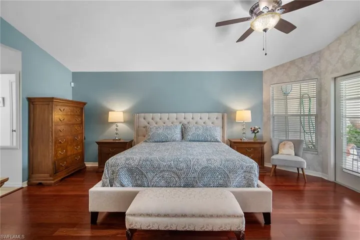 Bedroom featuring access to outside, multiple windows, dark wood-type flooring, and ceiling fan
