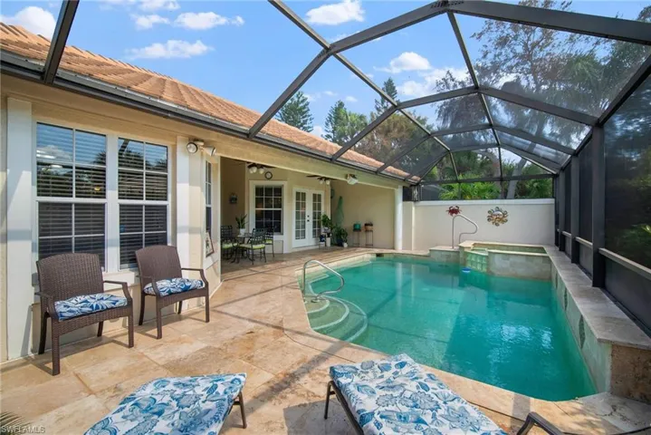 View of pool with a patio, ceiling fan, glass enclosure, and french doors