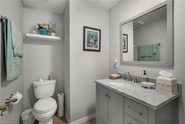 Bathroom with toilet, hardwood / wood-style floors, and vanity