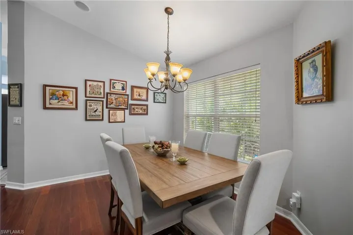 Dining space with a chandelier and dark hardwood / wood-style floors