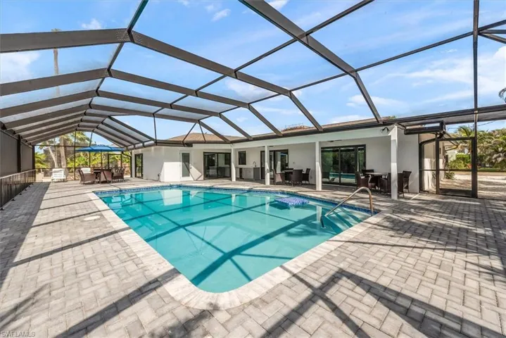 Swimming pool featuring outdoor dining area, a patio, a lanai, and an outdoor living space