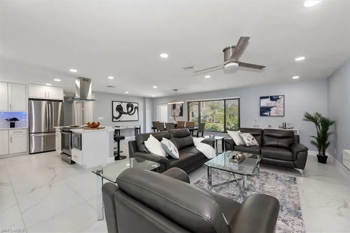 Living room featuring light marble finish flooring, recessed lighting, and ceiling fan