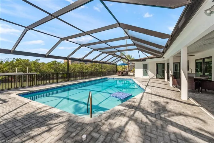 View of pool featuring a patio and glass enclosure