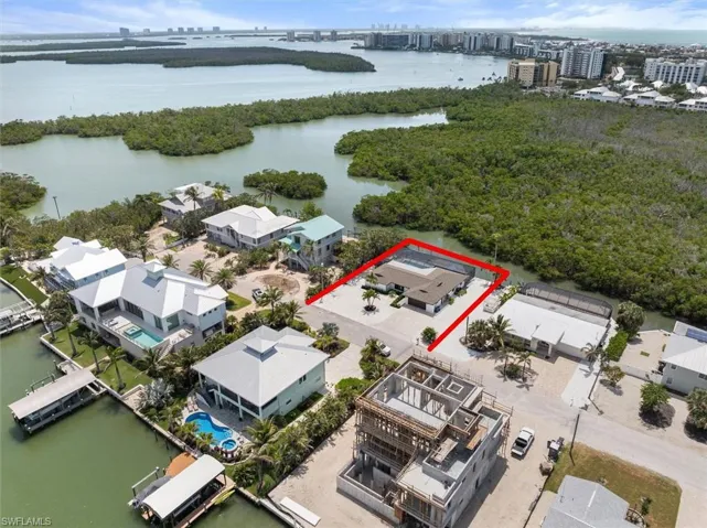Aerial overview of property's location featuring a nearby body of water, property parcel outlined, and a notable bridge