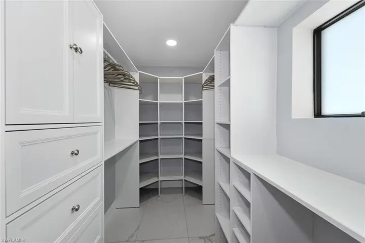 Walk in closet featuring light marble finish floors