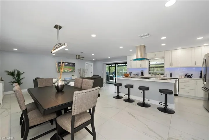 Dining area featuring light marble finish floors, recessed lighting, a ceiling fan, and baseboards