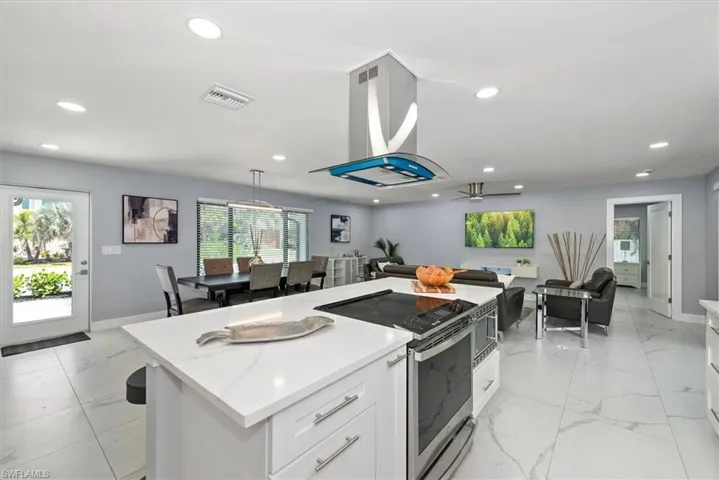 Kitchen with stainless steel range with electric cooktop, light marble finish flooring, white cabinets, healthy amount of natural light, and recessed lighting