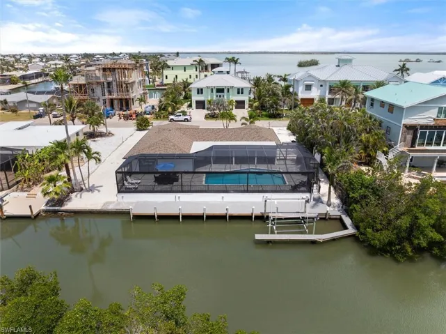 Aerial view of residential area with a large body of water and a pool
