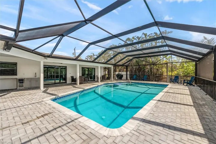 Outdoor pool with a patio and glass enclosure