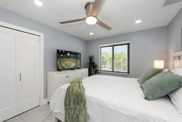 Bedroom featuring recessed lighting, ceiling fan, and light marble finish floors