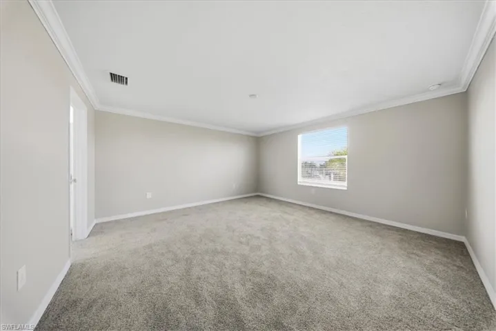 Unfurnished bedroom with a spacious closet and light carpet