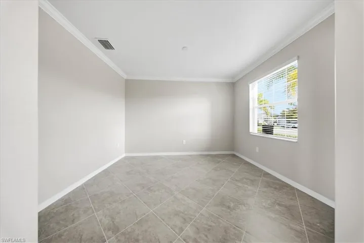 Unfurnished room featuring crown molding and baseboards